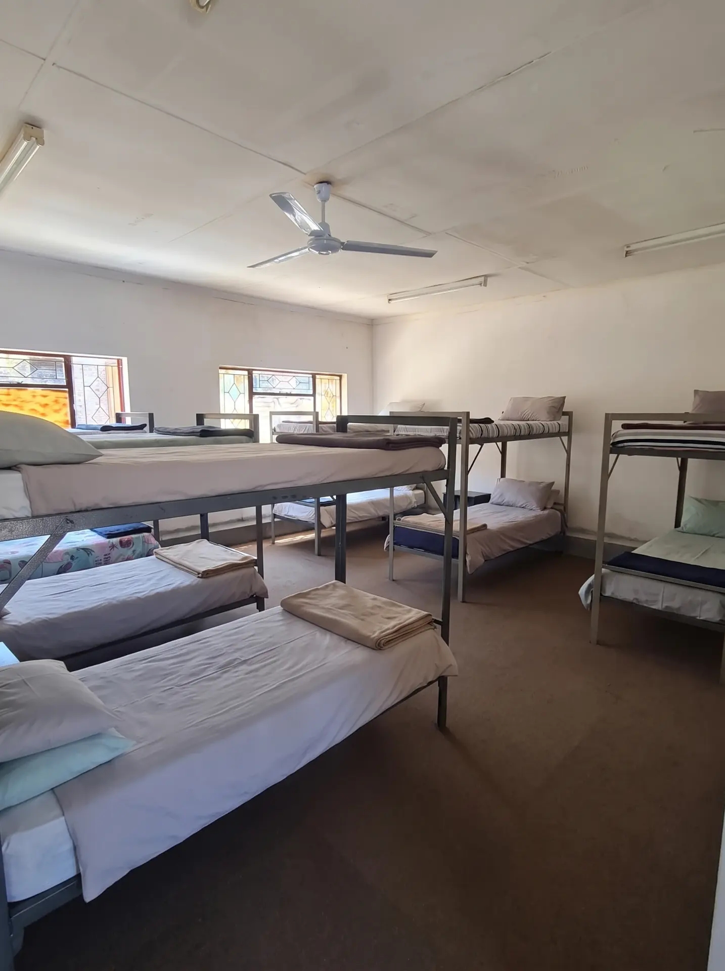 Girls' dormitory with neatly made beds and bunks