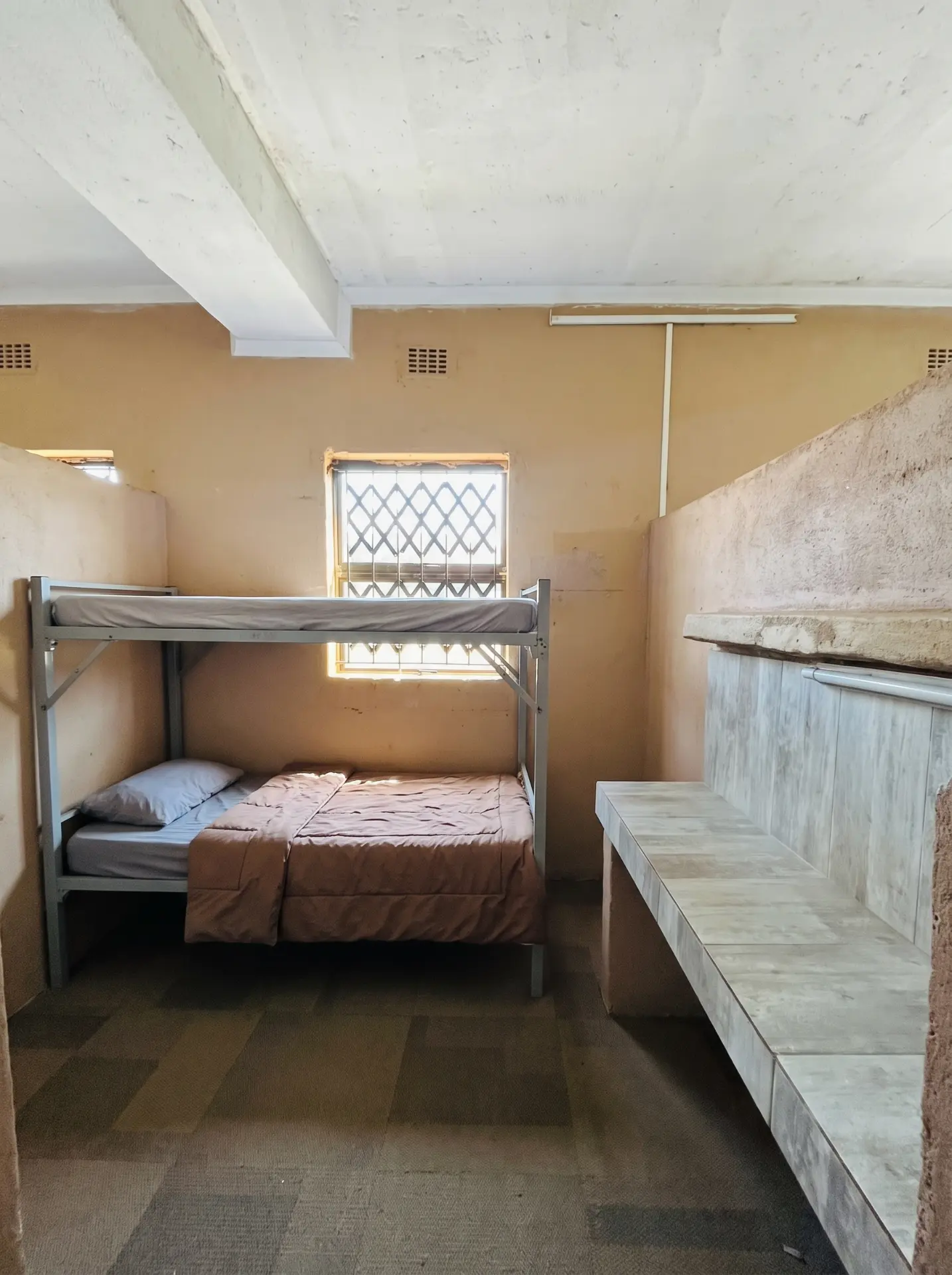 Bunk bed cubicle with bench seating in the boys' residence